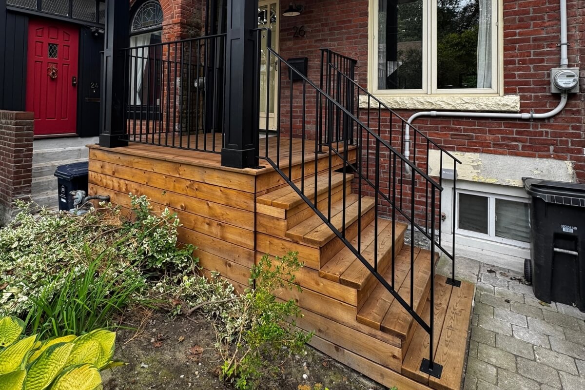 Black exterior steel railings on custom wooden porch and stairs by Rail Tech Construction