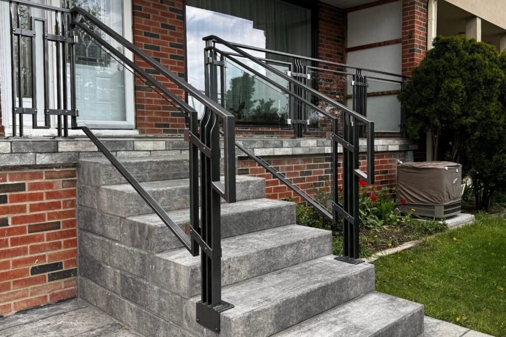 Custom black powder-coated galvanized steel railings installed on residential front porch and stairs